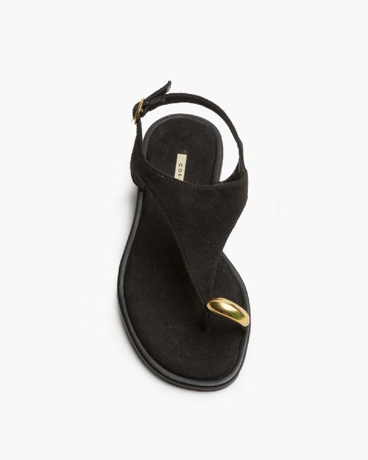 Sandalias negras planas con anillo metálico